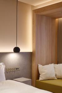 东京HotelCO Kuramae ホテル コ 蔵前的一间卧室配有一张床和吊灯