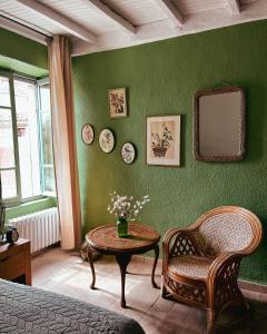 LussanChez Rosette de Lussan的绿色卧室配有桌子、椅子和镜子