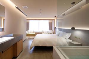 东京HotelCO Kuramae ホテル コ 蔵前的一间卧室配有一张玻璃墙床