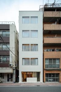 东京HotelCO Kuramae ホテル コ 蔵前的城市街道上的白色建筑,有建筑