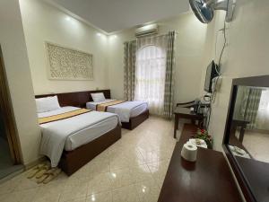 Yên BáiKhách sạn Phương Thuý 1的酒店客房设有两张床和电视。