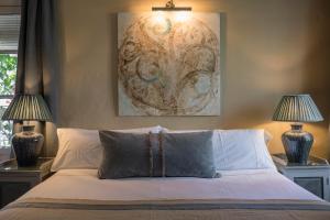 贝赫尔-德拉弗龙特拉卡利法之家酒店的一间卧室配有一张带两盏灯和一幅画的床铺
