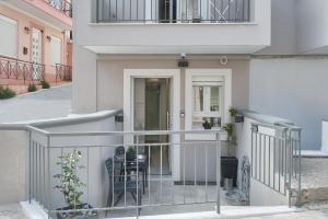 米蒂利尼Modern Studio for Two, Mytilene Lesvos的白色房屋 - 带椅子的阳台
