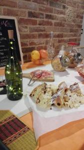 阿斯蒂San Rocco di Villa di Isola D'Asti的一张桌子,上面放着一盘食物和一瓶葡萄酒