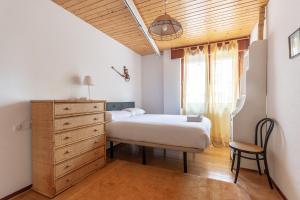 毕尔巴鄂Ganburu apartment by People Rentals的一间卧室配有一张床、一个梳妆台和一扇窗户。