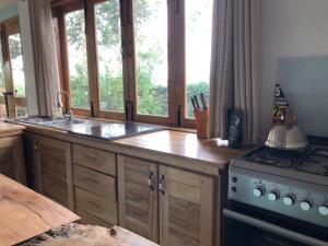 波特尔堡Baranko Villa的厨房配有水槽、炉灶和窗户。