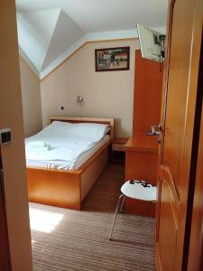 图兹拉Motel Royal的一间小卧室,配有一张床和一张桌子