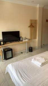 西哈努克西港宾馆的配有一张床和一台平面电视的酒店客房
