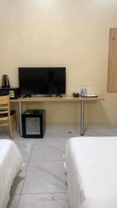西哈努克西港宾馆的一间设有一张桌子的房间,墙上有一台电视机