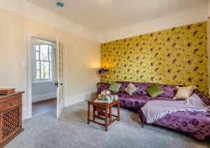 StradsettWaterhouse - Crimplesham Hall的一间卧室配有紫色沙发和黄色的墙壁