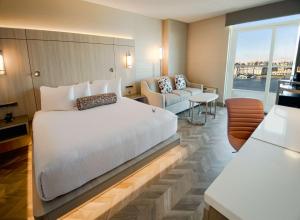 维多利亚维多利亚码头APA海岸酒店的卧室配有一张白色的大床和一张沙发。