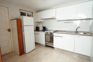 LariñoApartamentos Ancoradoiro的厨房配有白色橱柜和白色冰箱。