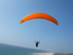 拉萨尔莱阿尔佩Hôtel Mont Thabor Serre Chevalier的骑着降落伞在海洋上空的人