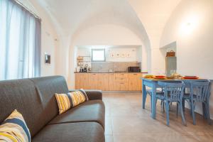滨海波利尼亚诺Poseidonia-Housea Travel的带沙发和桌子的客厅以及厨房。