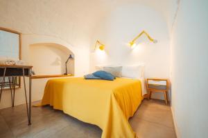 滨海波利尼亚诺Poseidonia-Housea Travel的一间卧室配有黄色的床和两个枕头