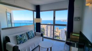 贝尼多姆Highrise apartment with private terrace & sea views - 34th floor的带沙发和大窗户的客厅