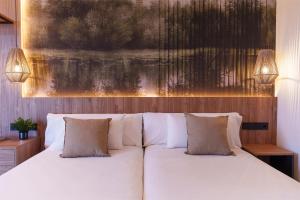 鲁韦纳Hotel Ciudad de Burgos的卧室配有白色的床和2个枕头