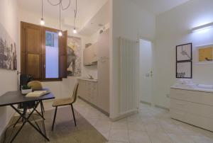 伊莫拉Imola Residence - Self Check-in的厨房配有桌子、椅子和书桌