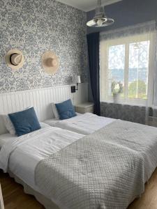 马斯特兰德航海酒店的卧室内的两张床,配有蓝色和白色的壁纸