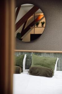 布雷达Hotel Botanique Breda的床上方的大镜子,带绿色枕头