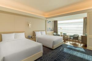 哈尔滨哈尔滨富力丽思卡尔顿酒店的酒店客房配有两张床和一张书桌