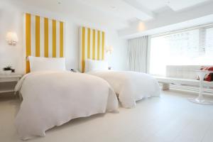 台北台北敦化美憬阁酒店的一间白色卧室,配有两张床和窗户