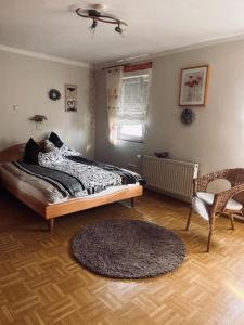 FreiensteinauFerienwohnung Langes的一间卧室配有一张床、一把椅子和地毯