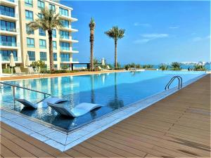 Durrat Al BahrainMarassi shores - 310的一座带两把椅子的游泳池以及一座建筑