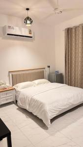 苏尔Tiwi Pearl的卧室配有一张白色大床和一张书桌