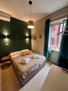 罗马多莫斯蒂贝里纳酒店的一间卧室配有一张床,上面有两条毛巾