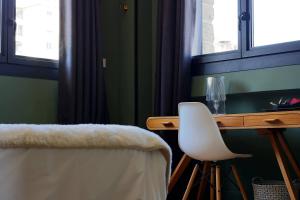 蒙彼利埃乐桑斯六酒店的一张桌子,旁边是一张白色椅子,靠窗