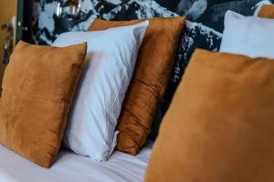 蒙彼利埃乐桑斯六酒店的床上的枕头堆,有棕色枕头