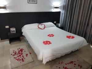 比塞大App S1 à l'hôtel Andalucia Beach的一张带白色毯子的床,上面有心
