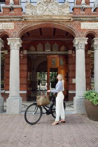 布雷达Hotel Botanique Breda的站在一辆自行车前面的女人