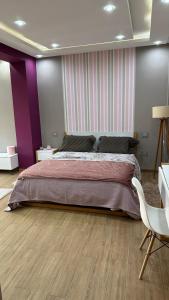 Ben ArousLuxury house with swimming pool的一间卧室设有一张大床和紫色的墙壁