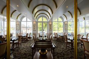 欧登塞Milling Hotel Plaza的用餐室设有桌椅和窗户。