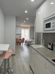 安特克拉Apartamentos Antequera的一间带白色橱柜的厨房和一间客厅