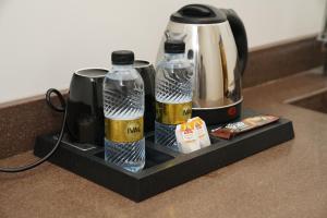 达曼view Rose Hotel Apartment的盘子上放有两瓶咖啡和咖啡壶