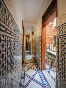 非斯Dar Dalila Fes的走廊上设有镜子,墙上铺有瓷砖