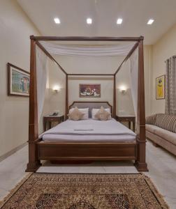 孟买Elphinstone Hotel的一间卧室配有一张带两个枕头的天蓬床