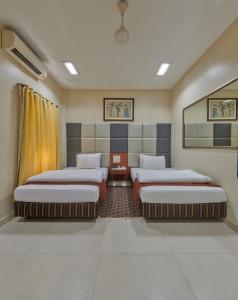 孟买Elphinstone Hotel的一间客房内配有两张床的房间