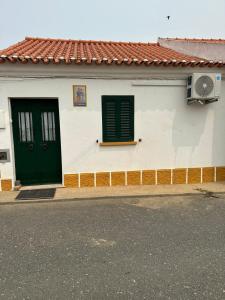 Santana de CambasCasa dos AVÓS的白色的建筑,设有绿色的门和窗户