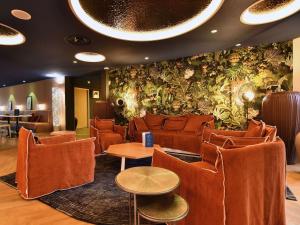 雷泽南特雷泽机场宜必思尚品酒店的一间设有橙色椅子和植物墙的等候室