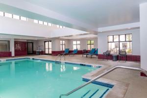 切斯特菲尔德圣路易斯切斯特菲尔德希尔顿恒庭旅馆&套房酒店的大楼内带蓝色椅子的大型游泳池