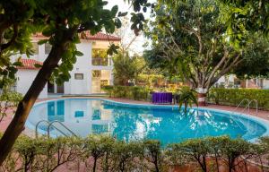 兰纳加Hridey Retreat Resort的一座树木繁茂的房屋前的游泳池