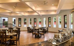 兰纳加Hridey Retreat Resort的用餐室设有桌椅和窗户。