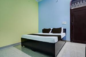 BulandshahrSPOT ON guest house的蓝色墙壁间的一张床位