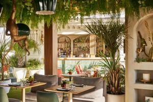 马德里马德里格兰大街中心凯悦酒店的一间设有桌椅的餐厅,种植了植物