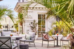 马德里马德里格兰大街中心凯悦酒店的庭院配有桌椅和棕榈树