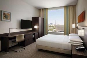 利雅德Hyatt Place Riyadh Sulaimania的配有一张床、一张书桌和一扇窗户的酒店客房